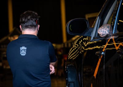 Jeep Invasion staff member talks with vehicle driver approaching the vendor area