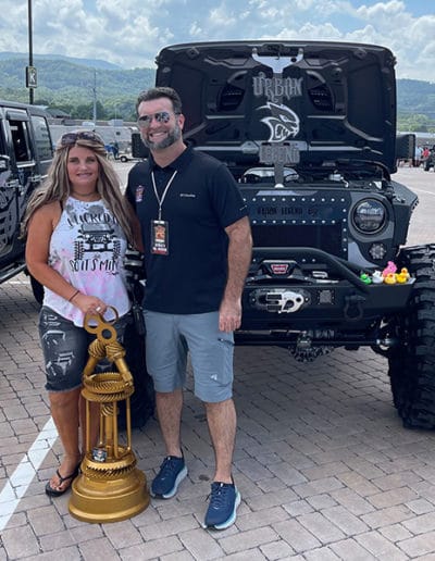 2021 award winner woman with black Jeep standing with man who presented award